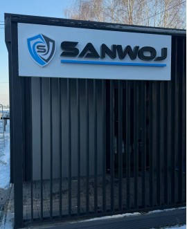 Litery blokowe 3D z logo firmowym na elewacji budynku, wykonane jako szyld reklamowy zewnętrzny.
