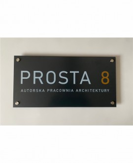Szyld z grafitowego dibondu z logo pracowni architektonicznej, druk UV, montaż ścienny na aluminiowych dystansach.